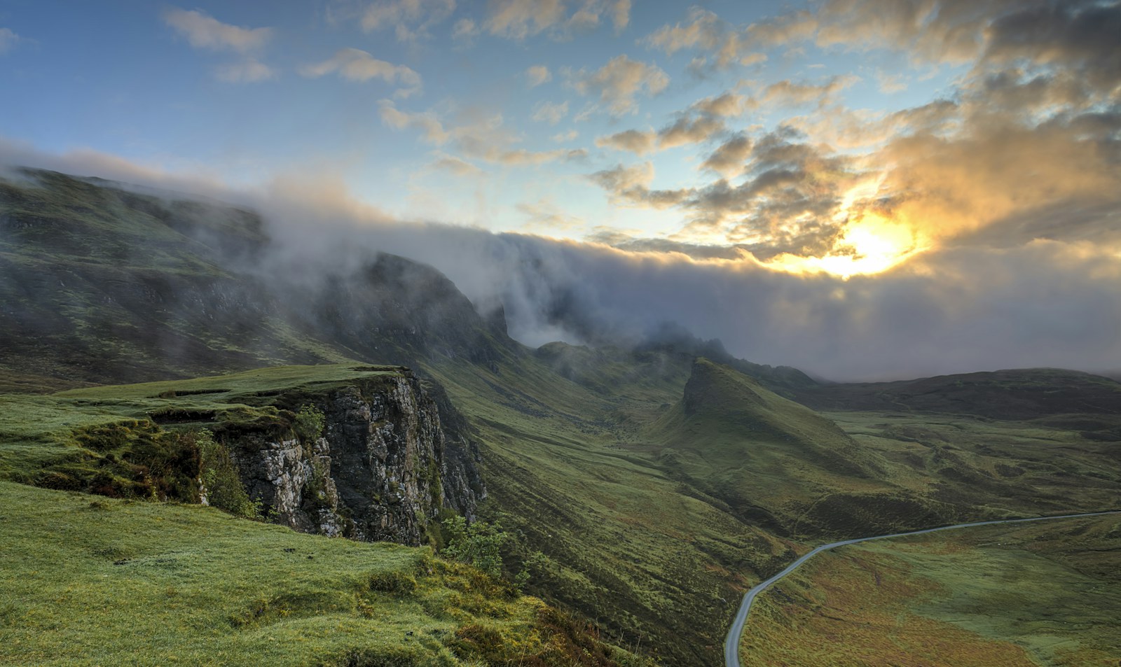 Layers of green mountains emerging from low mist